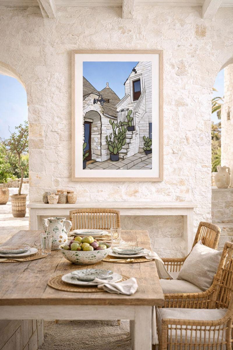 Dining area with a framed picture of a cactus on the wall, wooden table, and wicker chairs.