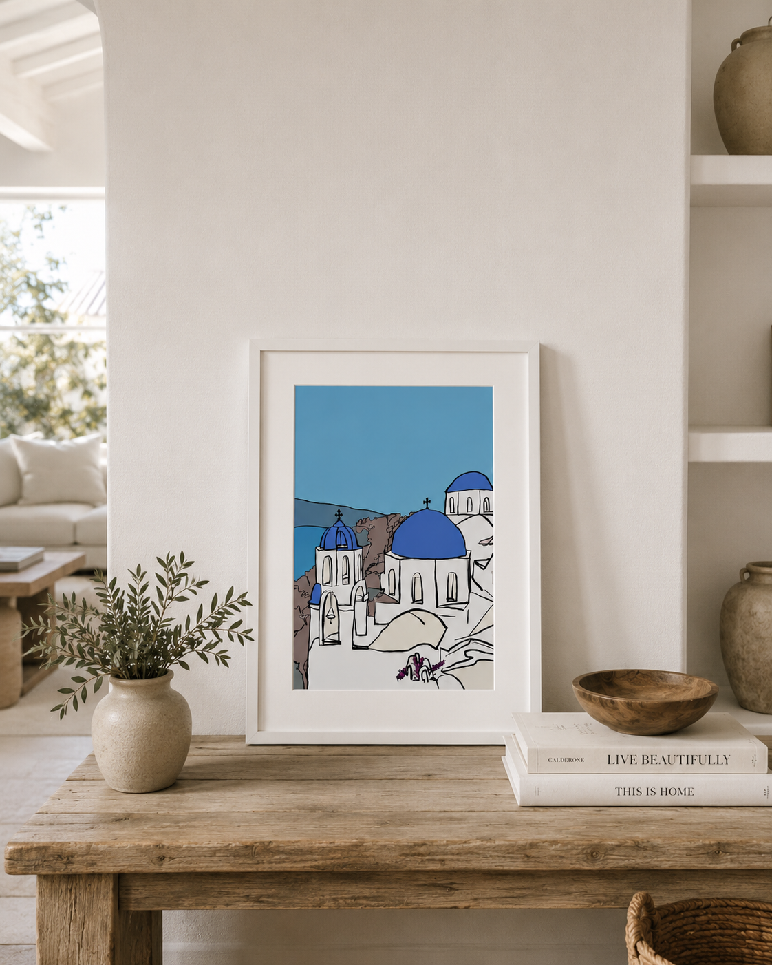 A3 Santorini print styled on a wooden table with plants and books