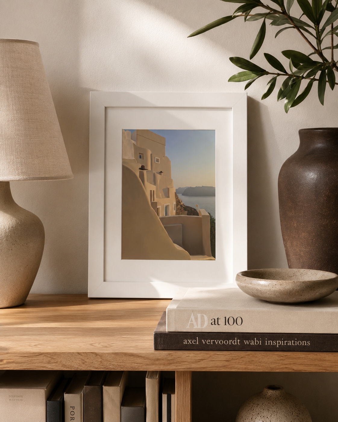 A4 Oia Santorini print styled on a shelf with a lamp and vase