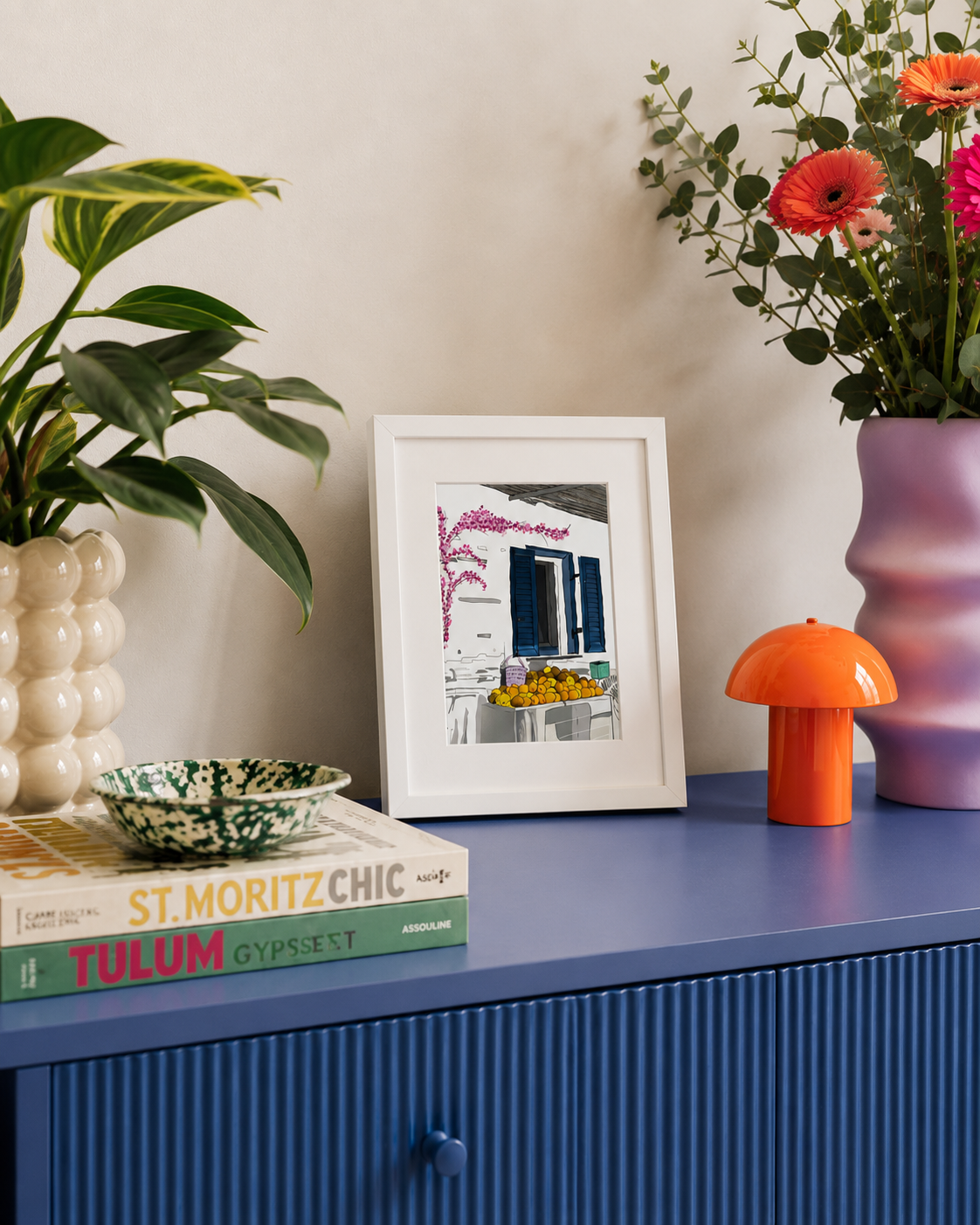 A5 Milos print styled on a blue cabinet with flowers and books