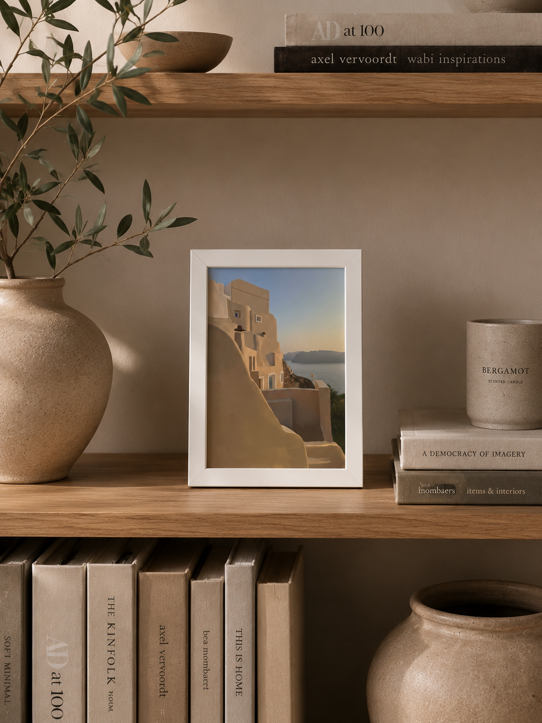A5 Oia Santorini print styled on a shelf with books and a vase