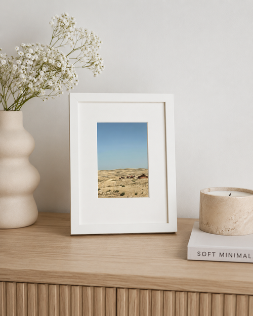 A5 Agafay Desert print framed on a wooden sideboard with flowers and a candle