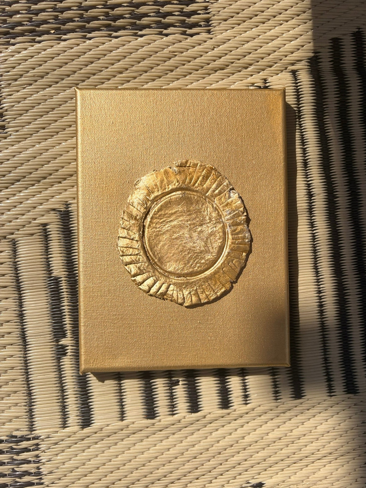 Eclipse ceramic art on gold canvas, raised metallic gold ruffled circular design, on floor