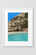 Framed Sifnos Chairs print of lounge chairs by a cliffside pool