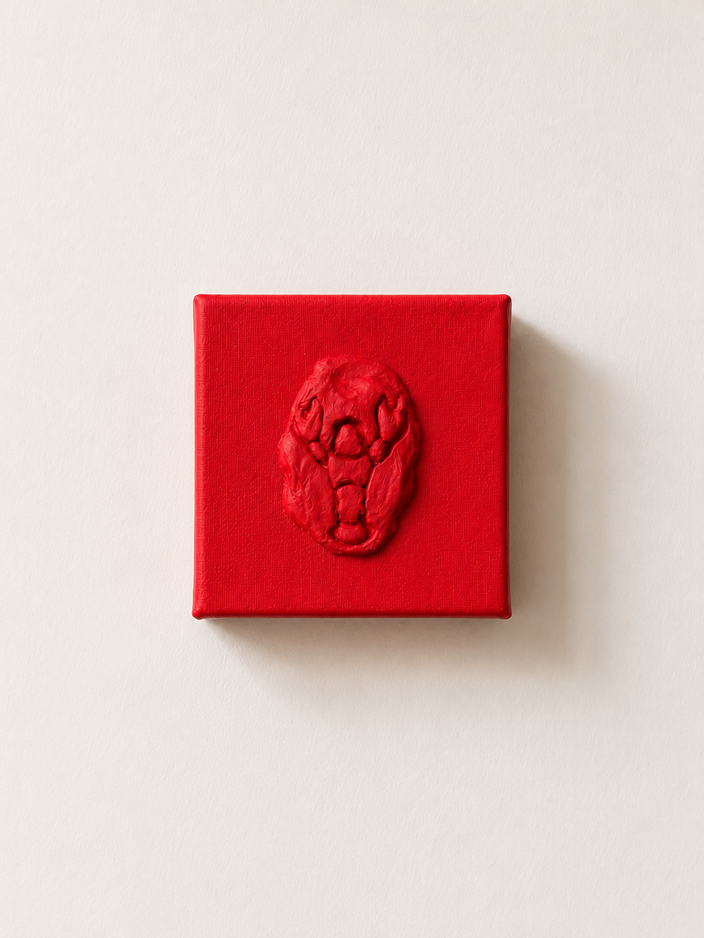 Lobster Rosso Grande — a small red ceramic sacred heart emblem mounted on a red box canvas, photographed against a plain white wall