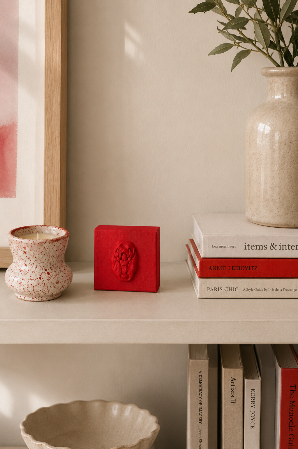 Lobster Rosso Grande — a small red ceramic sacred heart emblem mounted on a red box canvas, photographed in a home