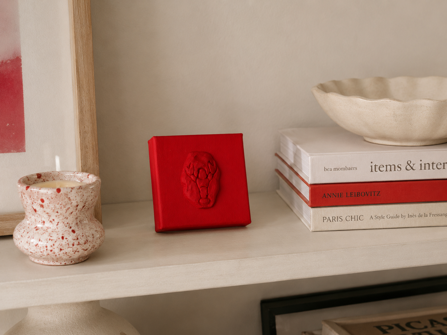 Lobster Rosso Grande — a small red ceramic sacred heart emblem mounted on a red box canvas, photographed on a shelf