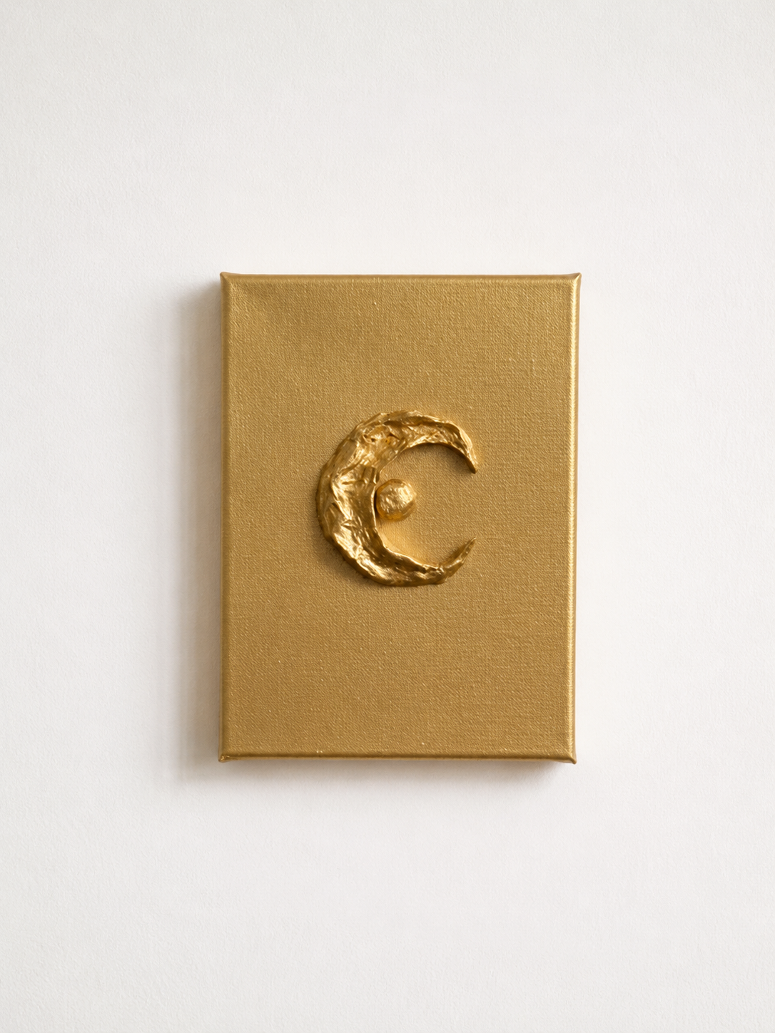 Luna ceramic art on gold canvas, raised metallic gold crescent moon and star design, white background