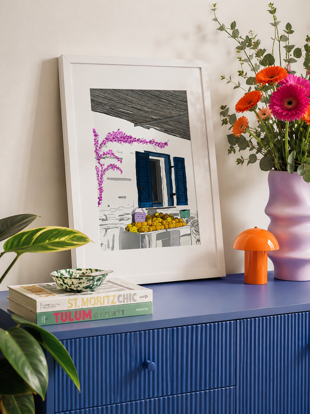 Milos print styled on a blue cabinet with flowers and a lamp
