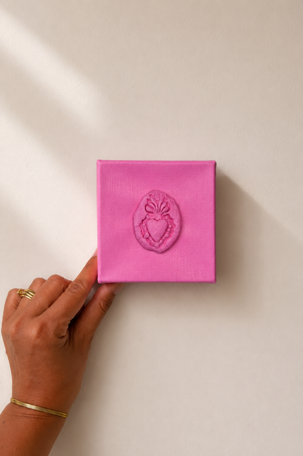 Sacro Cuore Rosa Grande — a small pink ceramic sacred heart emblem held on a plain white background