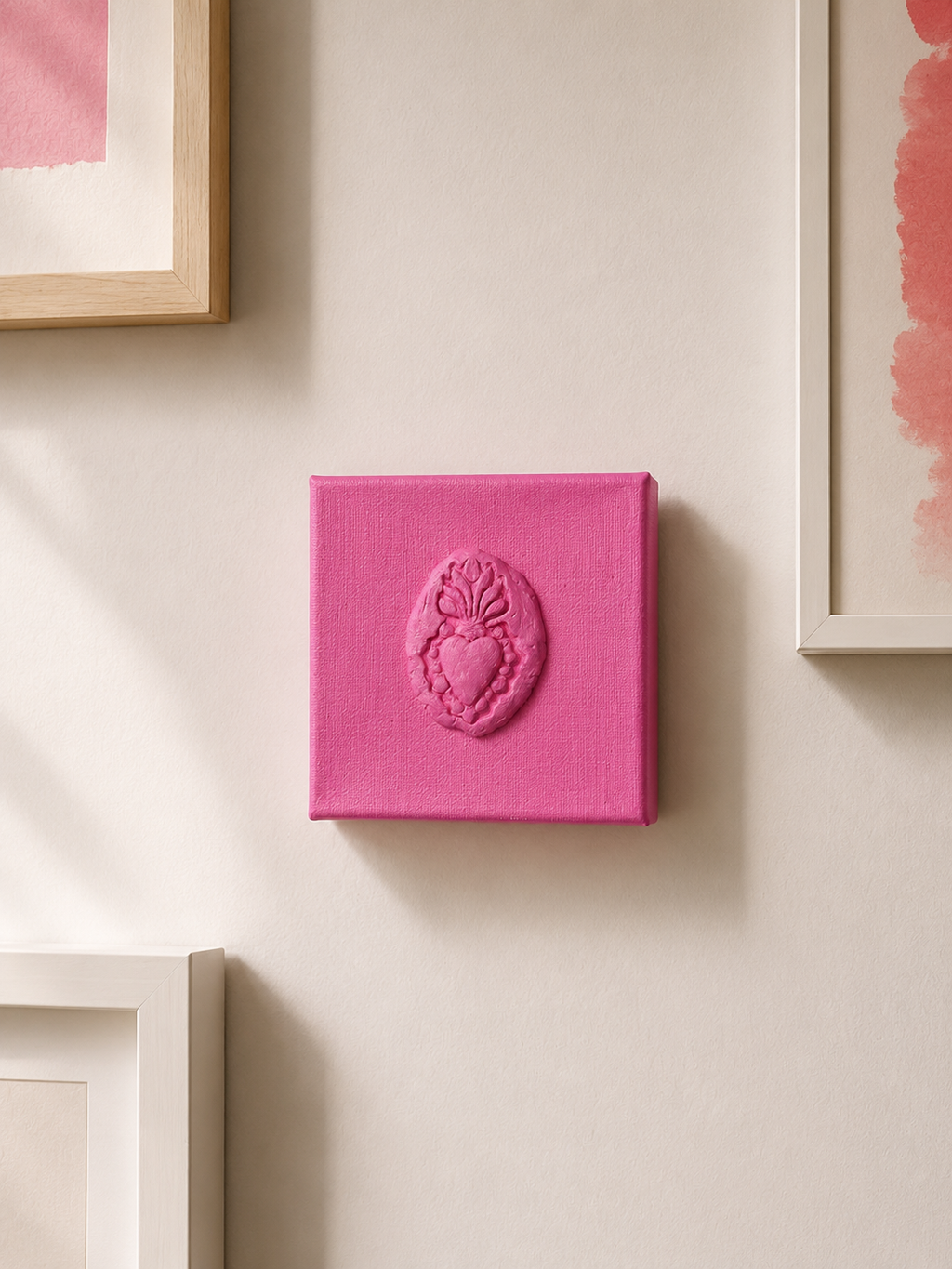 Sacro Cuore Rosa Grande — a small pink ceramic sacred heart emblem mounted on a gallery wall