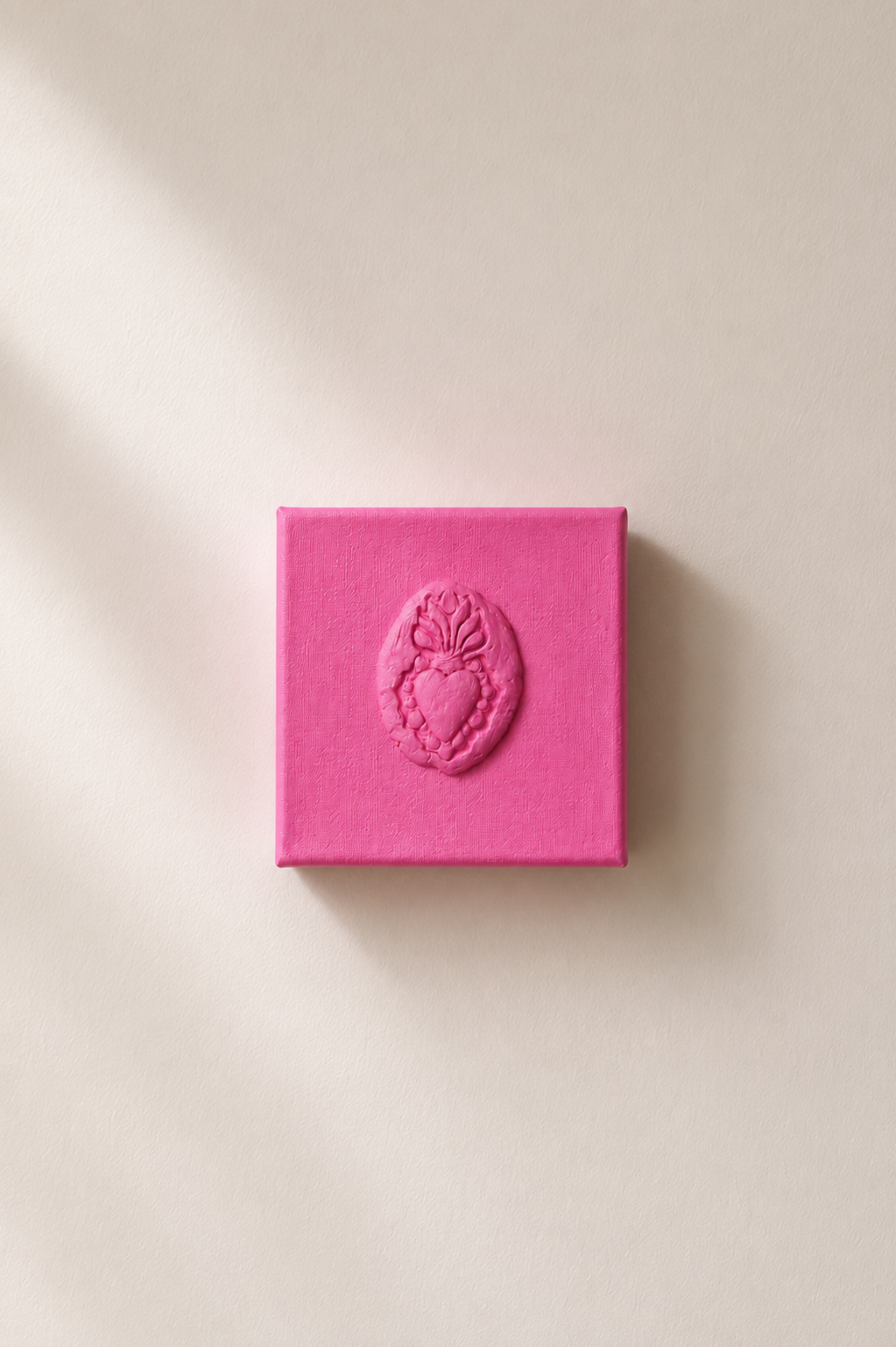 Sacro Cuore Rosa Grande — a small pink ceramic sacred heart emblem mounted on a plain white background
