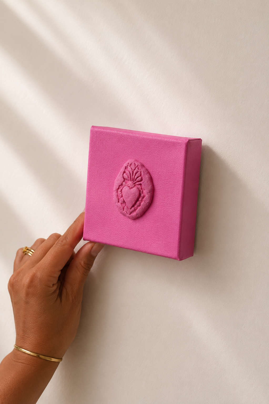 Sacro Cuore Rosa Grande — a small pink ceramic sacred heart emblem mounted on a plain white background, different angle