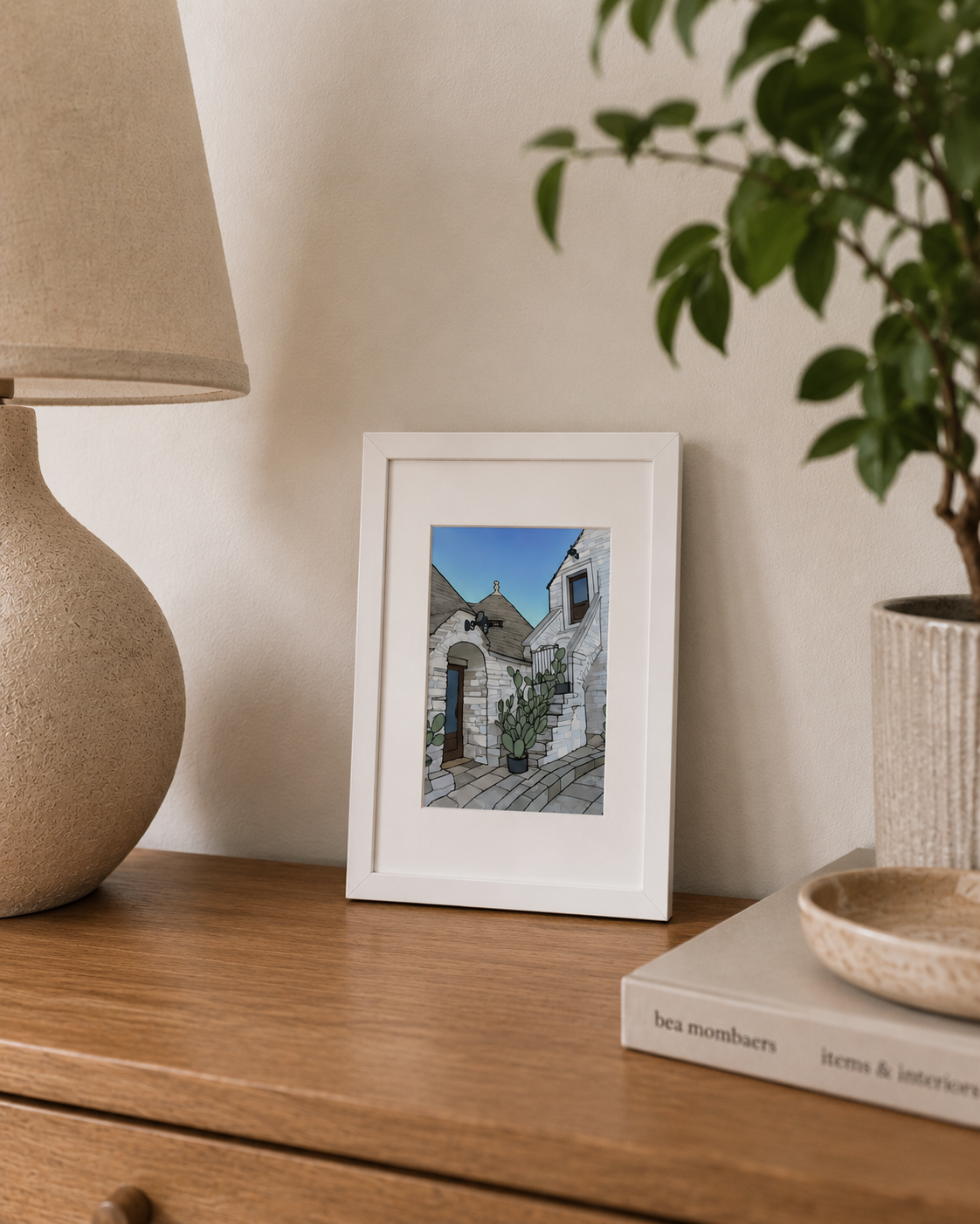 A5 Alberobello print styled on a wooden sideboard with a lamp and plant