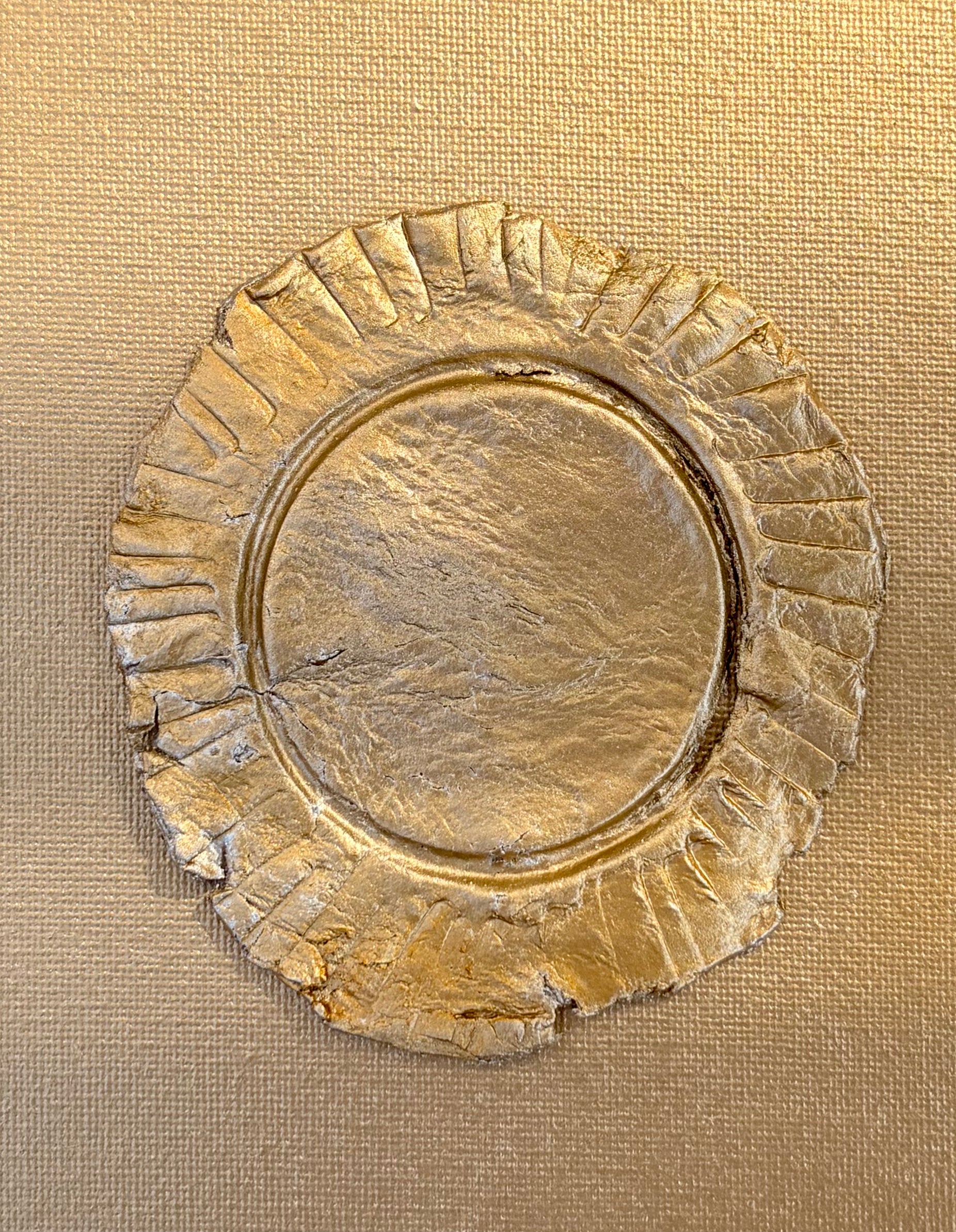 close up Eclipse ceramic art on gold canvas, raised metallic gold ruffled circular design